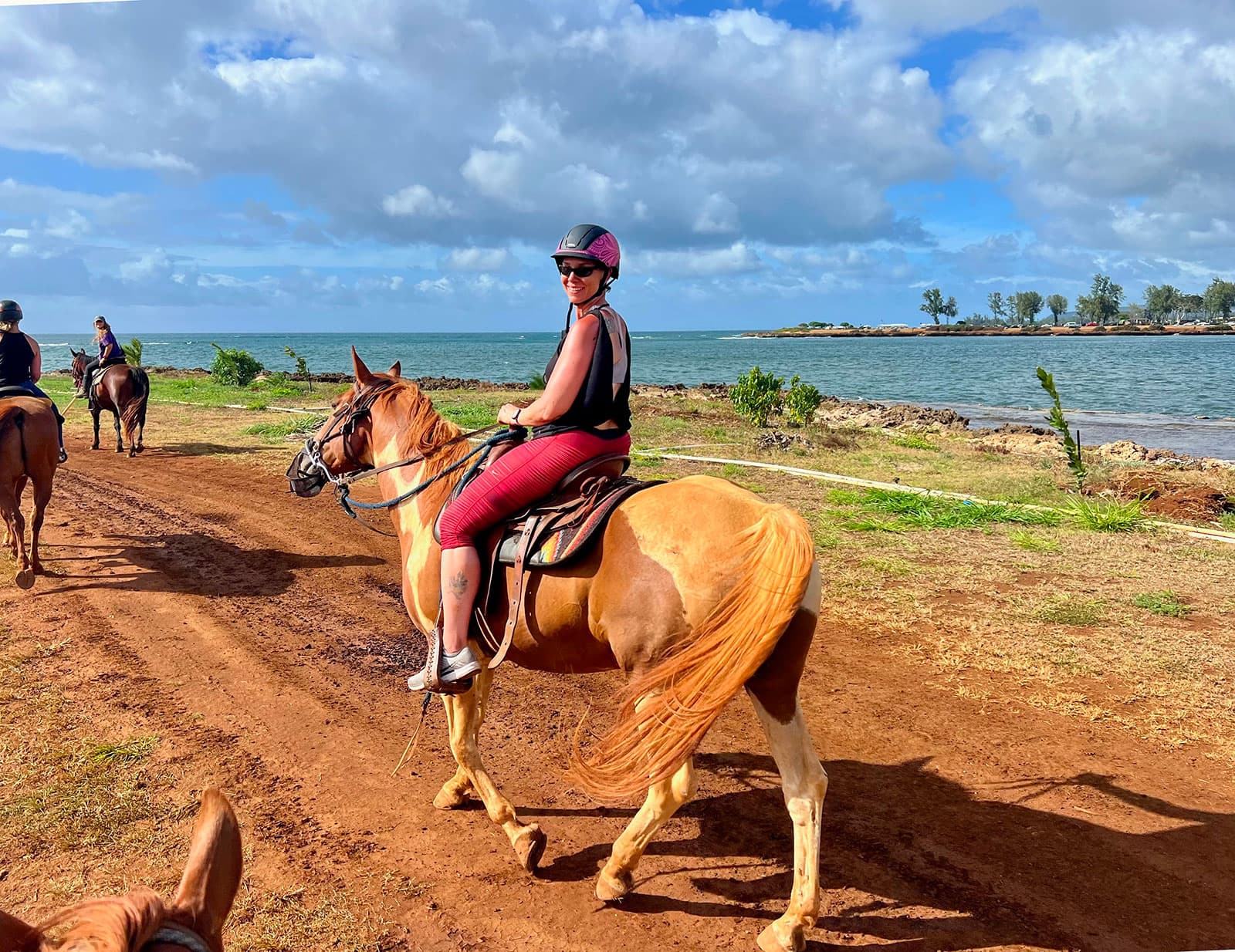 Jennifer riding a horse beside the Oahu coast
