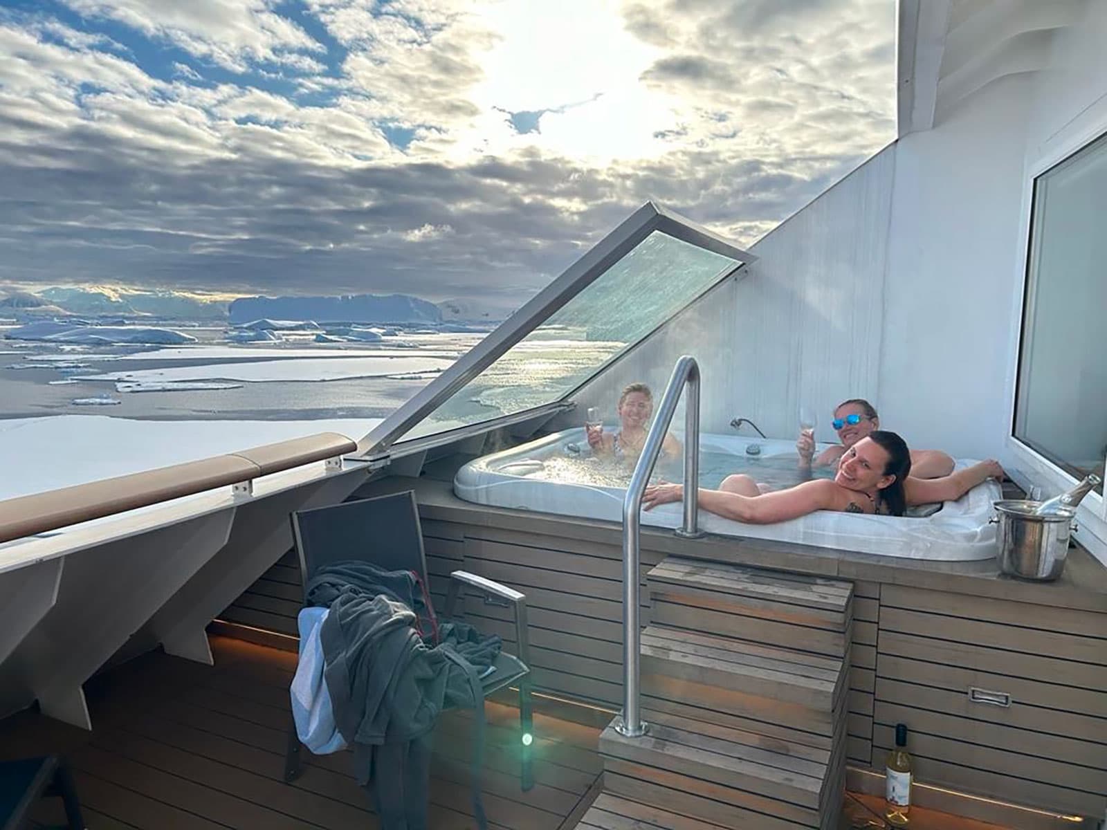 Friends relaxing in an outdoor hot tub aboard the expedition ship