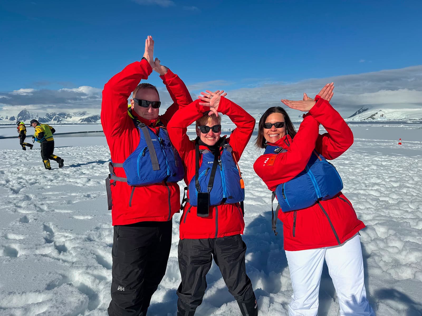 Three travelers making petrel poses during an ice landing
