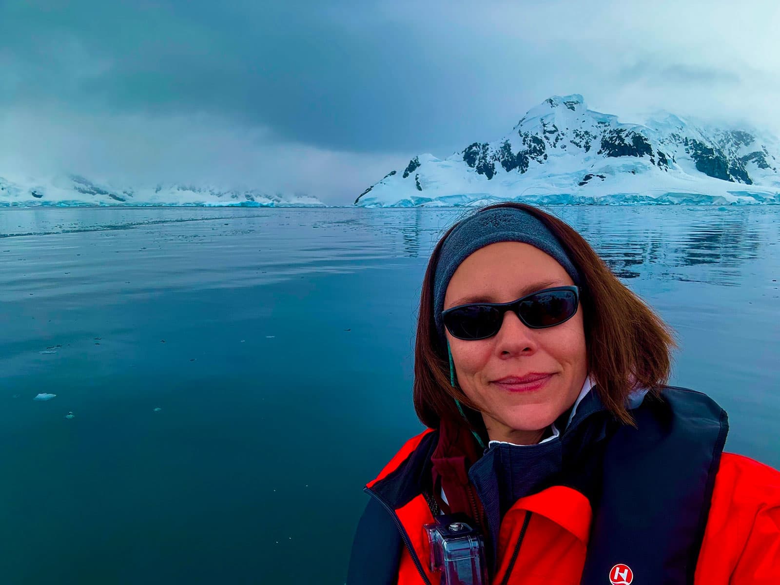 Jennifer aboard a Zodiac surrounded by calm water and mountains