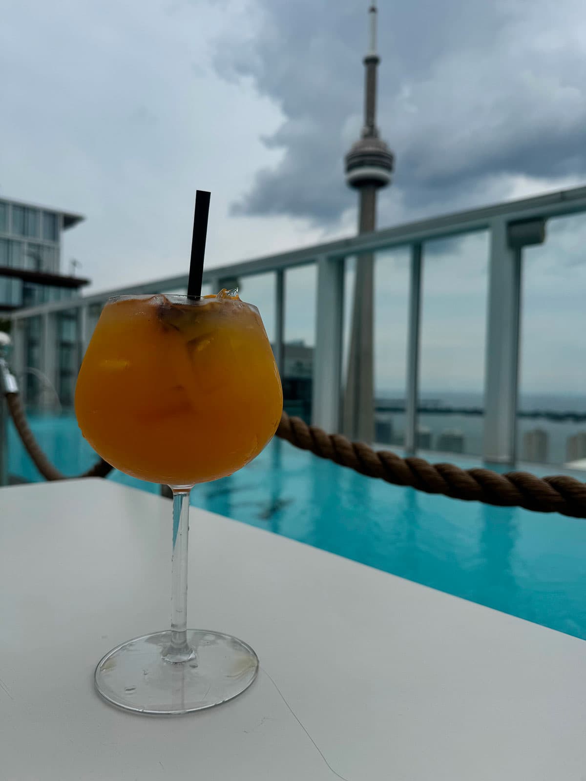 Rooftop drink with a pool and the CN Tower behind
