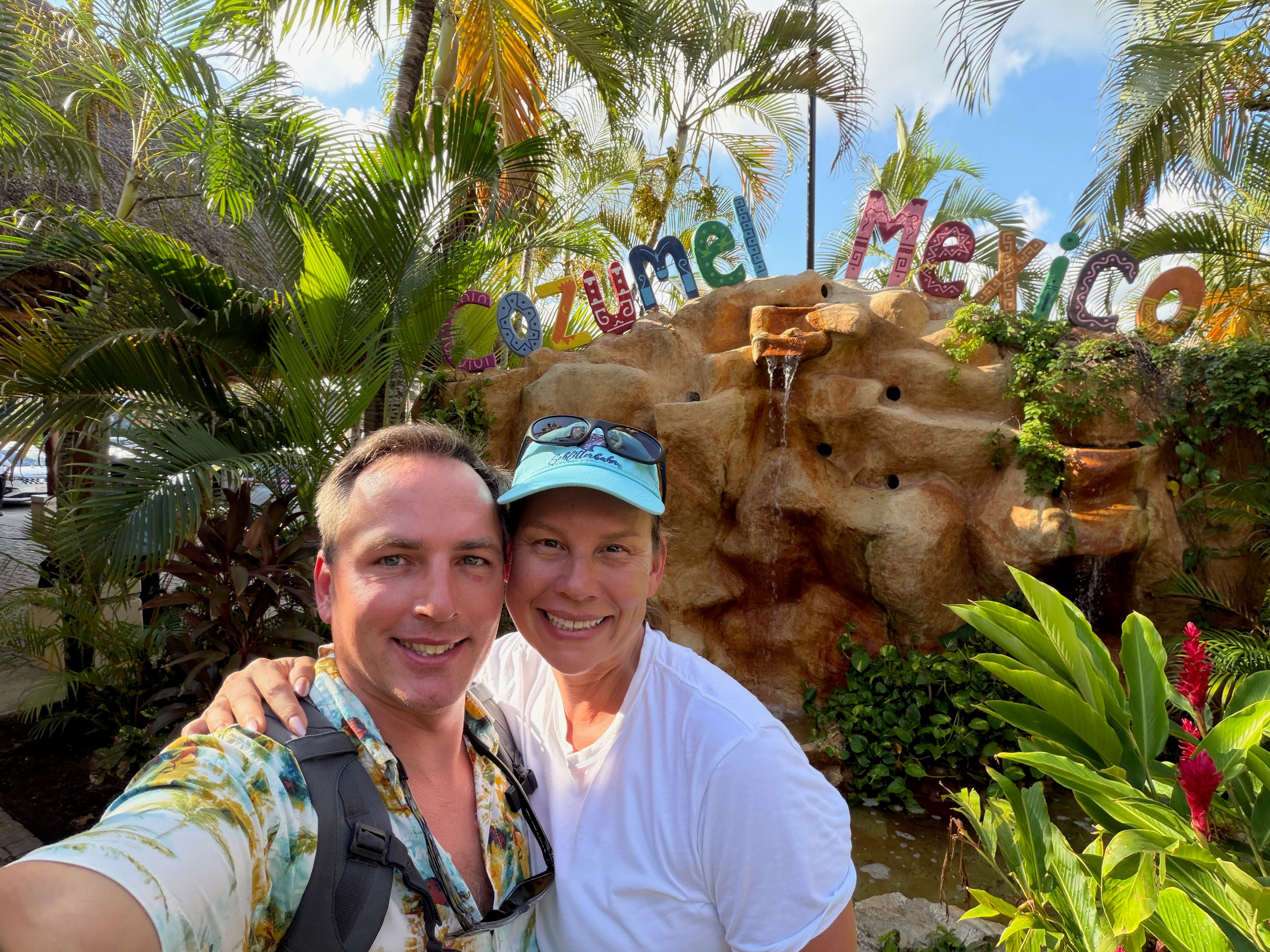 Jen and Kevin smiling together in front of the Cozumel, Mexico sign