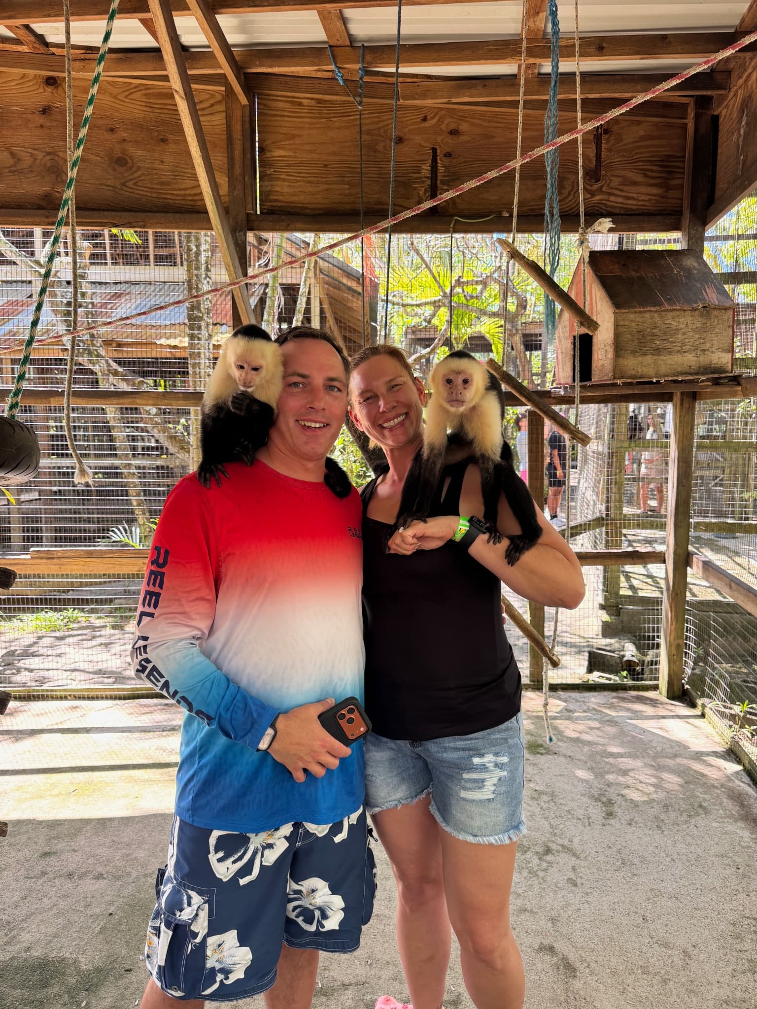 Jennifer and a companion with capuchin monkeys in an enclosed setting
